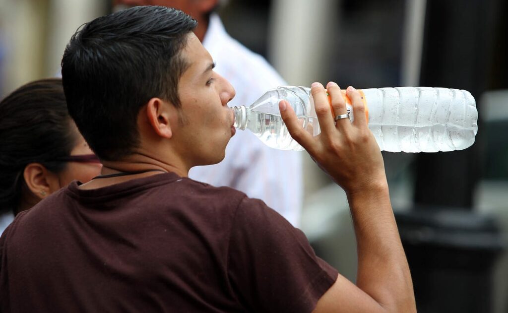 Chico mexicano tomando agua embotellada